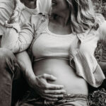 Maternity photoshoot of couple sitting in the grass