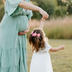 Mom and little girl twirling at west park in Westfield, indiana during maternity session