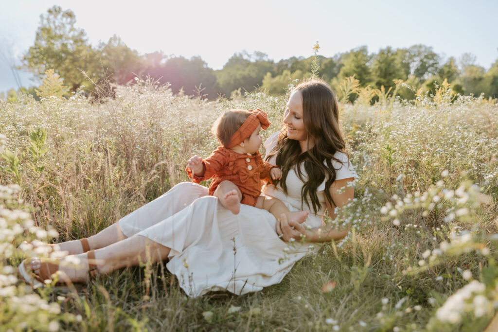 Mom at West Park in North  Indy sitting in tall flowers with her baby